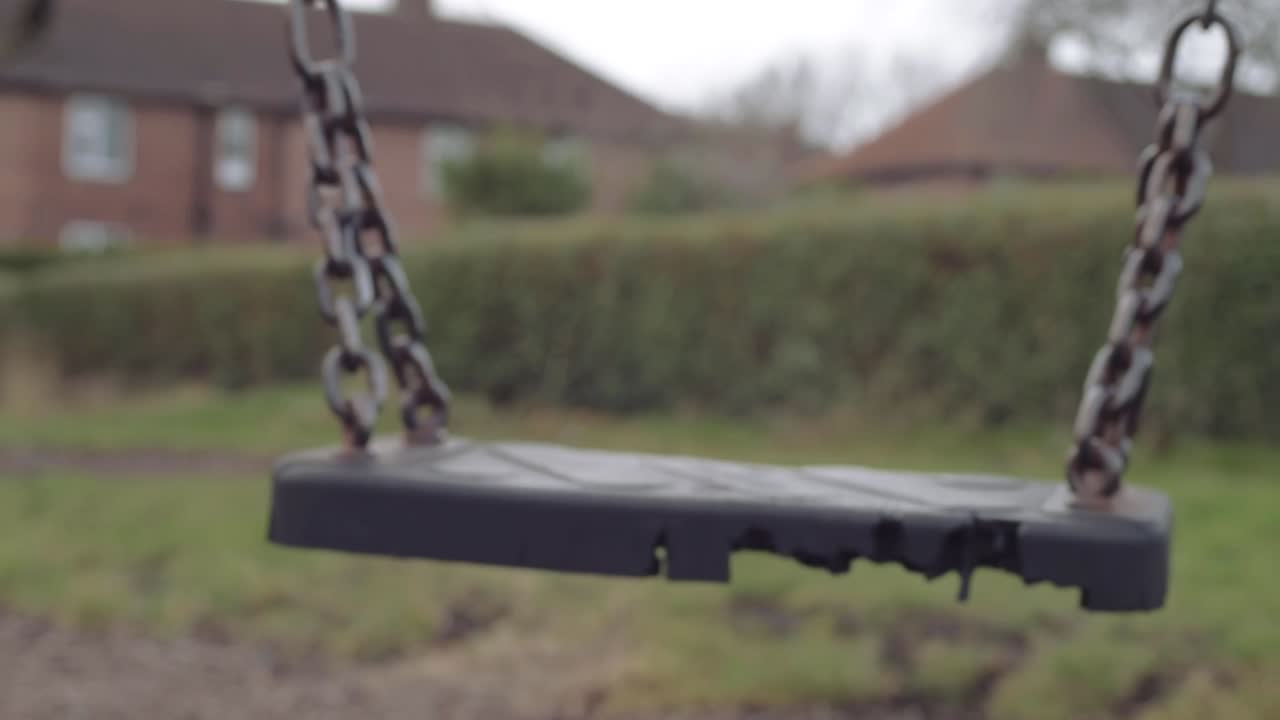 Empty black swing in an urban park playground