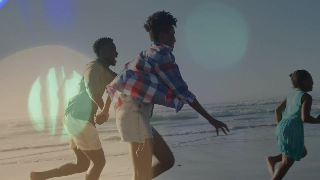 Child sprinting ahead urging adults joining family chase on wet sand while lens flare overlaying