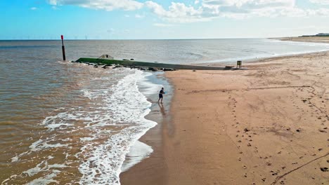 Young-boy-playing-on-the-beach-and-in