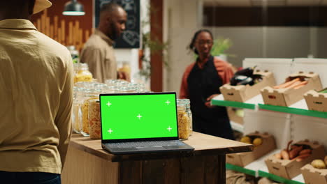 laptop on stall at supermarket showing greenscreen template