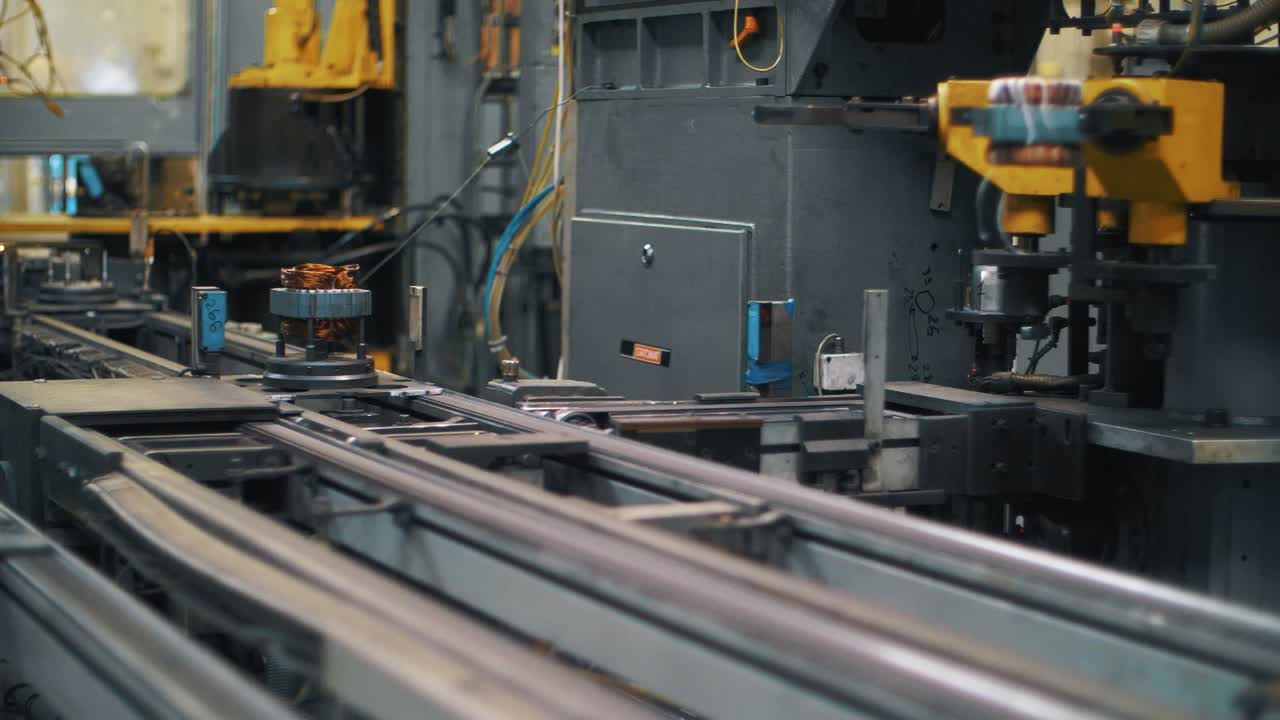 Metal detail with copper wire moving on automatic conveyor on factory