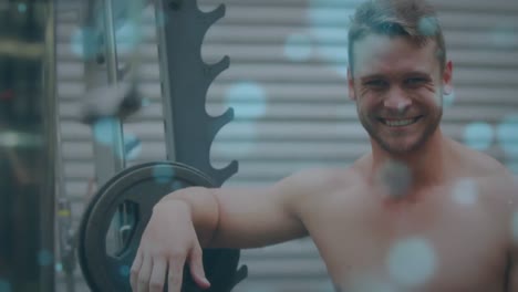animación de manchas brillantes sobre un hombre fuerte haciendo ejercicio en el gimnasio