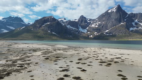 Vista-Aérea-En-órbita-Sobre-La-Hermosa-Playa-De-Morfeo-Con-Grandes-Montañas-Nevadas