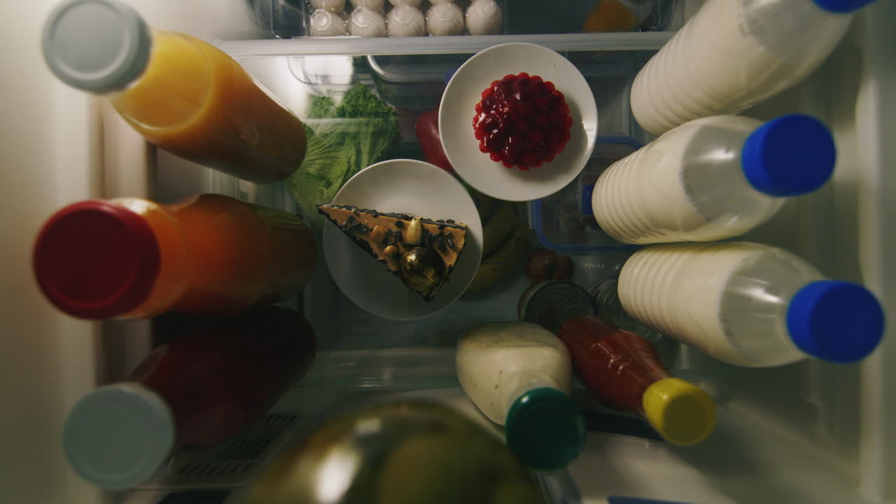 manos femeninas toman dos pedazos de pastel del refrigerador