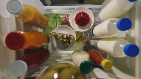 female hands take two pieces of cake from the refrigerator