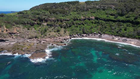 turquoise seascape surrounding wybung head lookout in frazer park, new south wales, australia - drone shot
