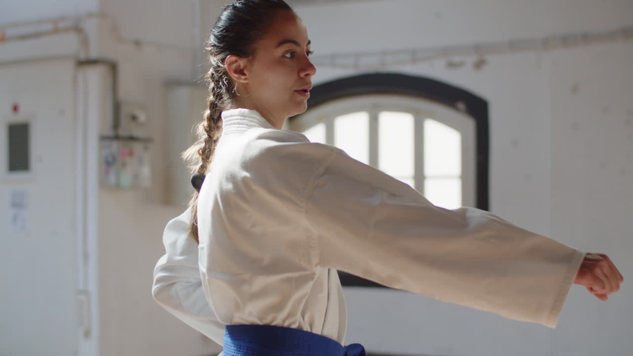 체육관에서 훈련하는 자신감 있는 무술가의 중간 샷