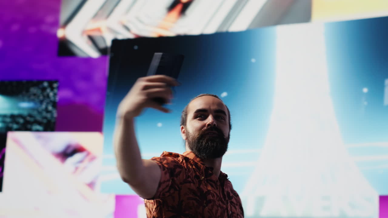 Cool relaxed guy using his smartphone under neon lights
