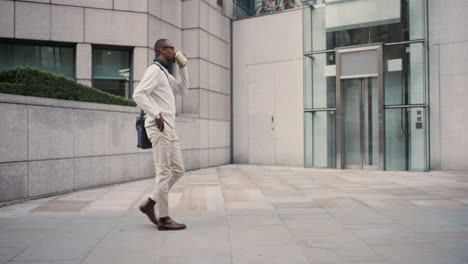 african american businessman walking through city