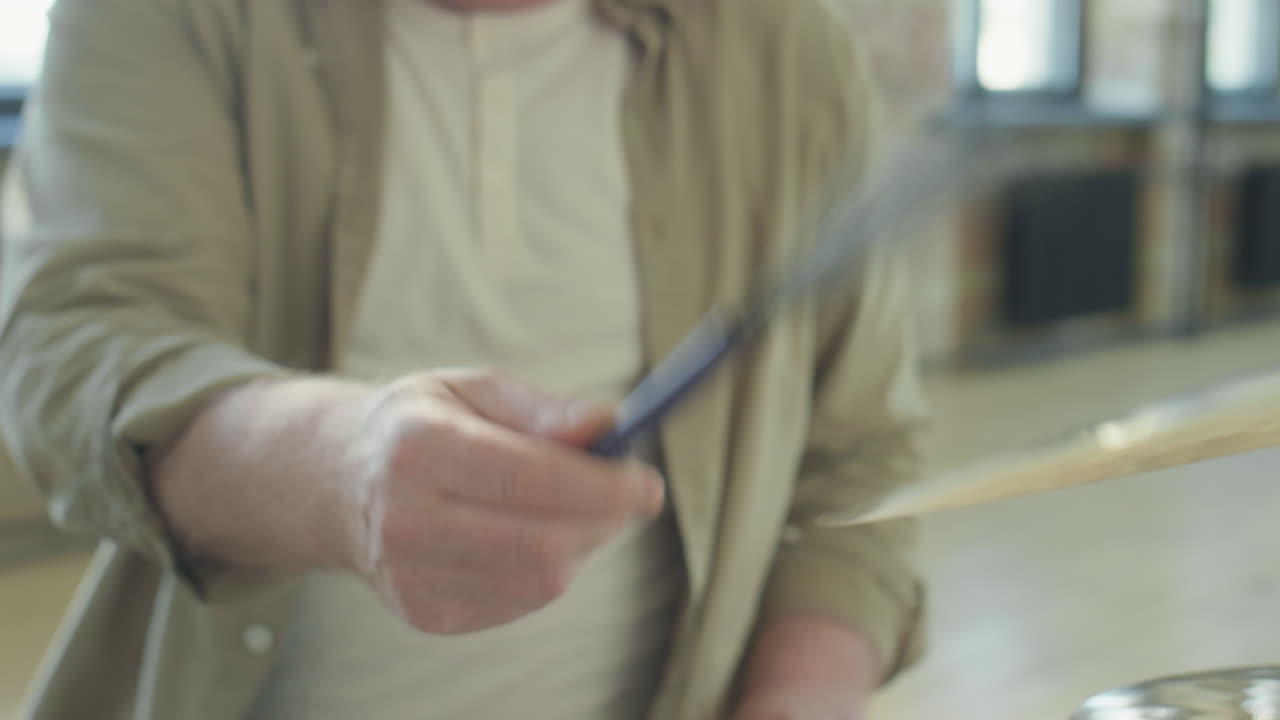 Senior Musician Playing Drumset with Drum Brushes