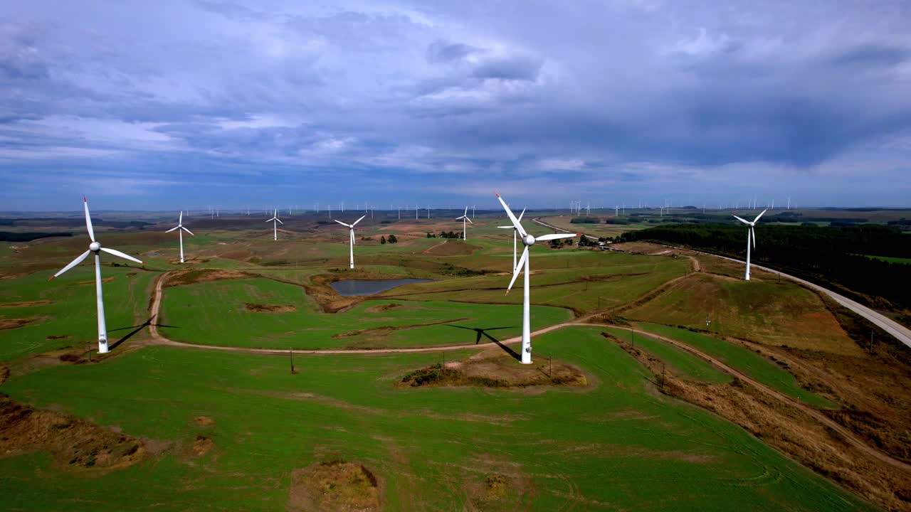 Wind turbine farm generating renewable energy on a hilltop - aerial view