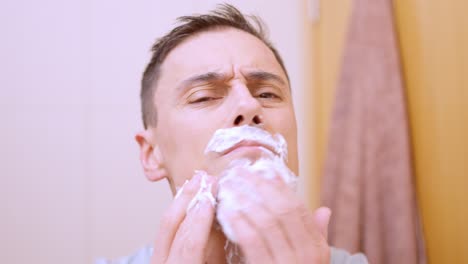 Man applying shaving foam on his face in bathroom