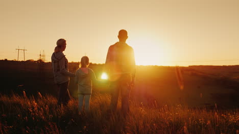 A-Family-Of-Three-People-Meets-The-Sunrise-In-A-Picturesque-Place-On-The-Mountain