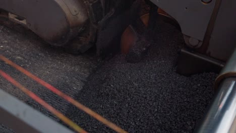 fresh asphalt to be distributed on the ground for road construction, top down view from high angle, slow motion