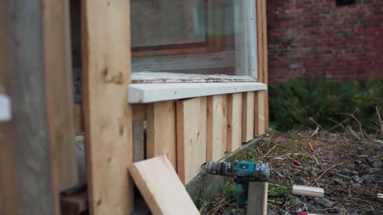 Uomo che installa assi di legno su un ingresso