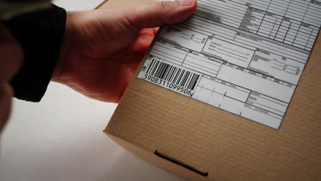 Scanner scan delivery box in storage, E-commerce shop, man packing goods and clothes second hand delivery market, courier Packaging and Shipping Workspace with Supplies and Technology, online sales.