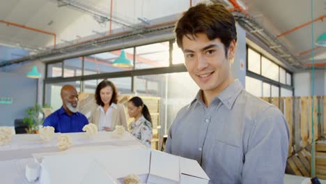 male executive holding architectural model in the office 4k