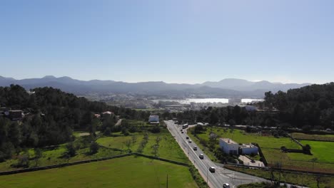 drone shot high rising by a road with fields on both side on ibiza