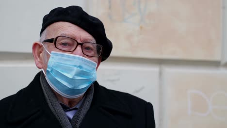 portrait of a caucasian grandfather wearing a blue protective mask. security for health in old age.