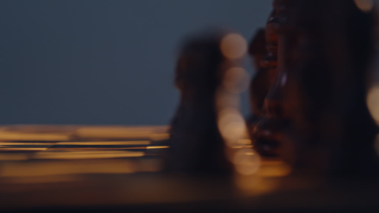 Gamer hand pressing chess piece across checkered square surface indoors closeup