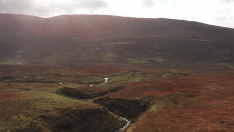 aerial drone flyover a river valley in fairy glen in skye scotland autumn