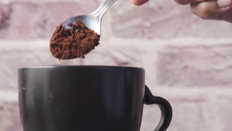 adding coffee powder to cup