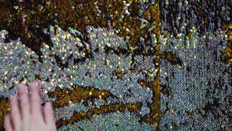 close-up of sequined fabric with hand