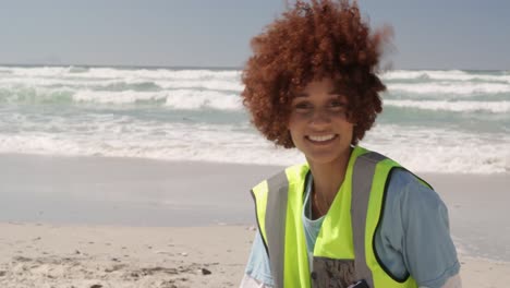 front view of african american female volunteer cleaning beach on a sunny day 4k