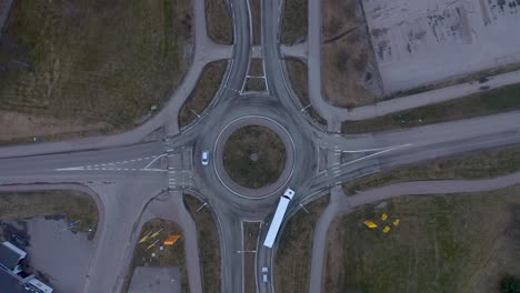 drone footage showing cars and a truck driving in and out of a roundabout on a cloudy day in march 2020