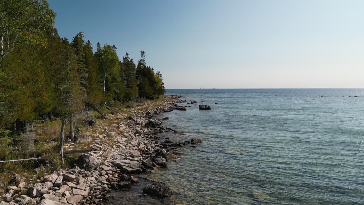 미시간 주 휴론 호수 의 숲 과 바위 가 있는 해안선 을 통과 하는 공중 비행