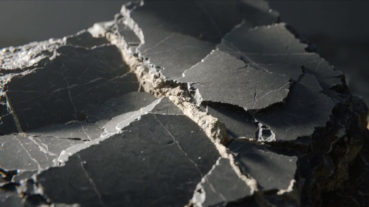 Moving camera revealing disc shard on studio table to reveal central crack texture under side light