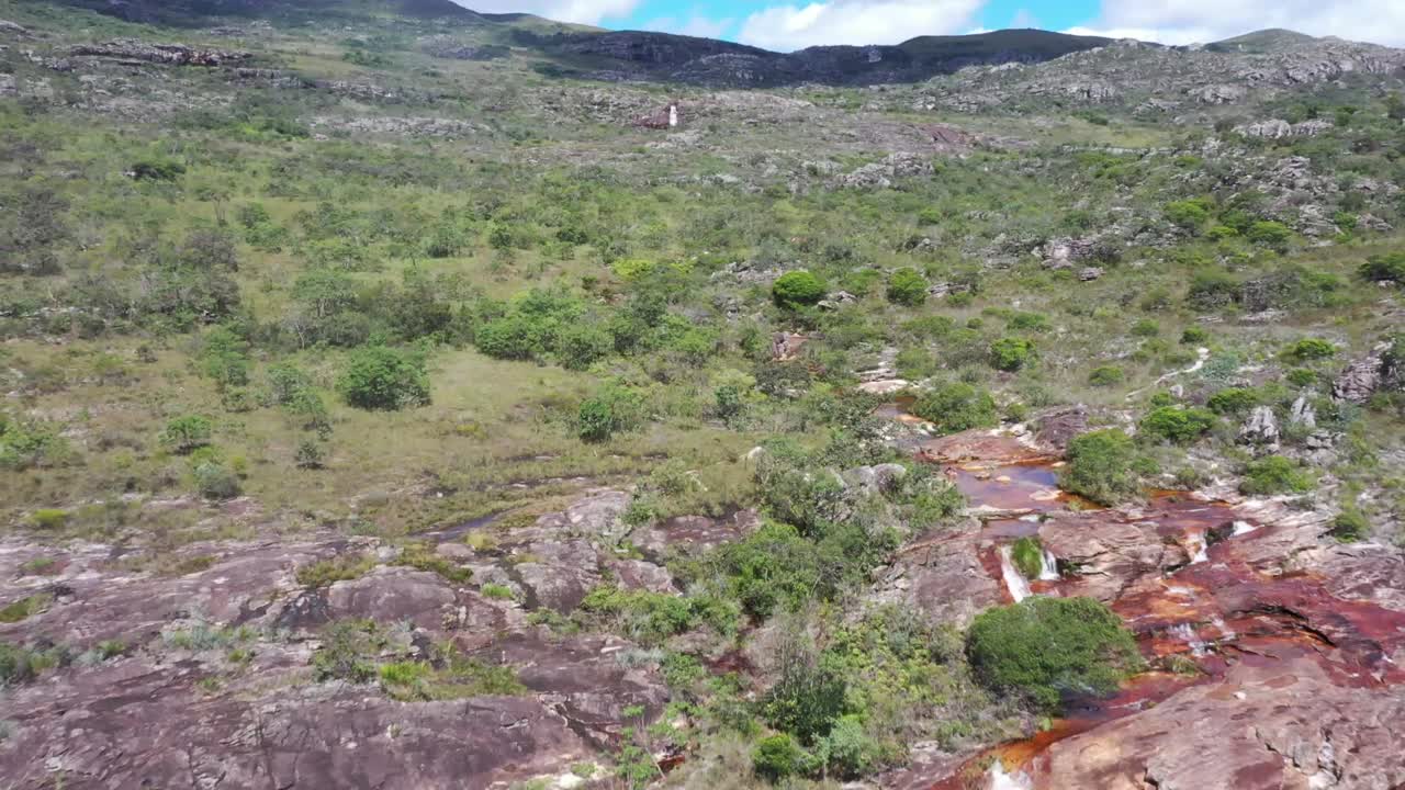 toma aérea de drones de un río rocoso duro con fondo marrón en medio de colinas secas