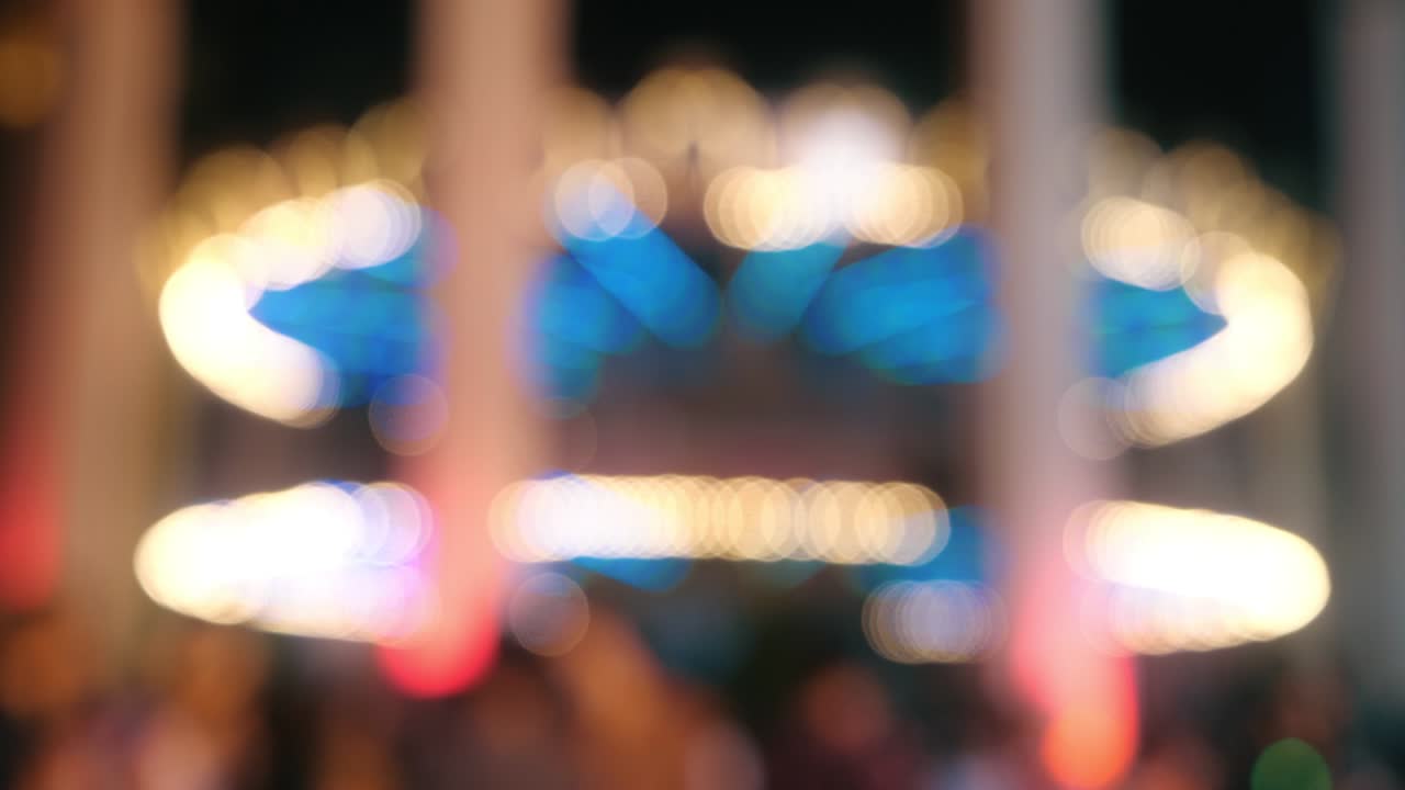 Blurred background of Incredible colorful flashing light of vintage carousel carnival fair merry go round circus horse ride at amusement park.