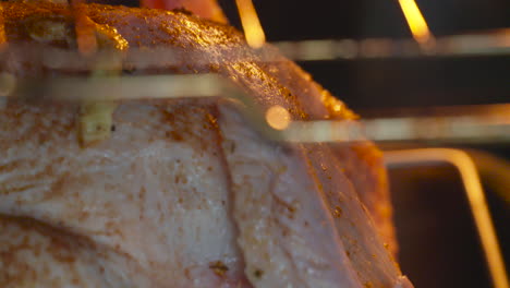 closeup of a seasoned turkey cooking in a hot oven