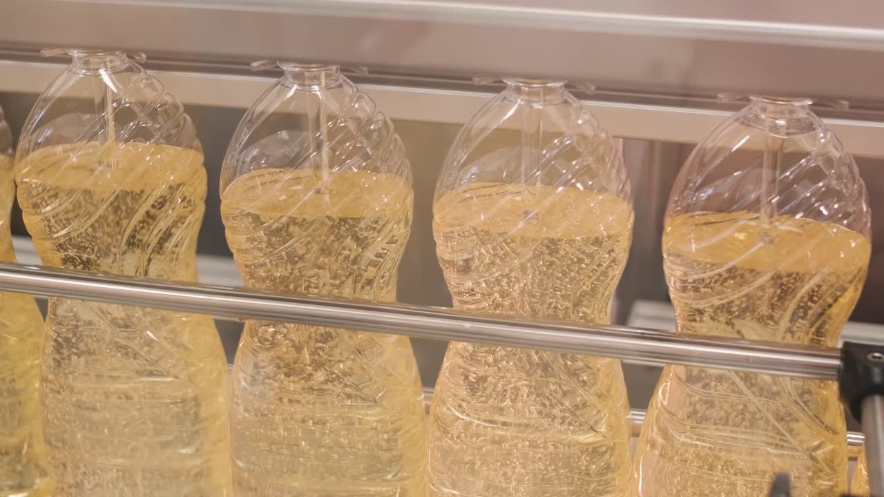 생산 라인에서 움직이는 병에 있는 해바라기 기름. 병에 담긴 해바라지 기름을 병에 담는 라인. 식물성 기름 생산 공장. 첨단 기술. 산업적 배경