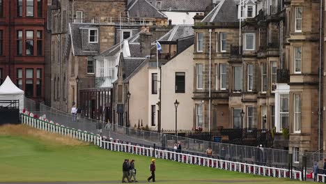 people walking by historic buildings and golf course