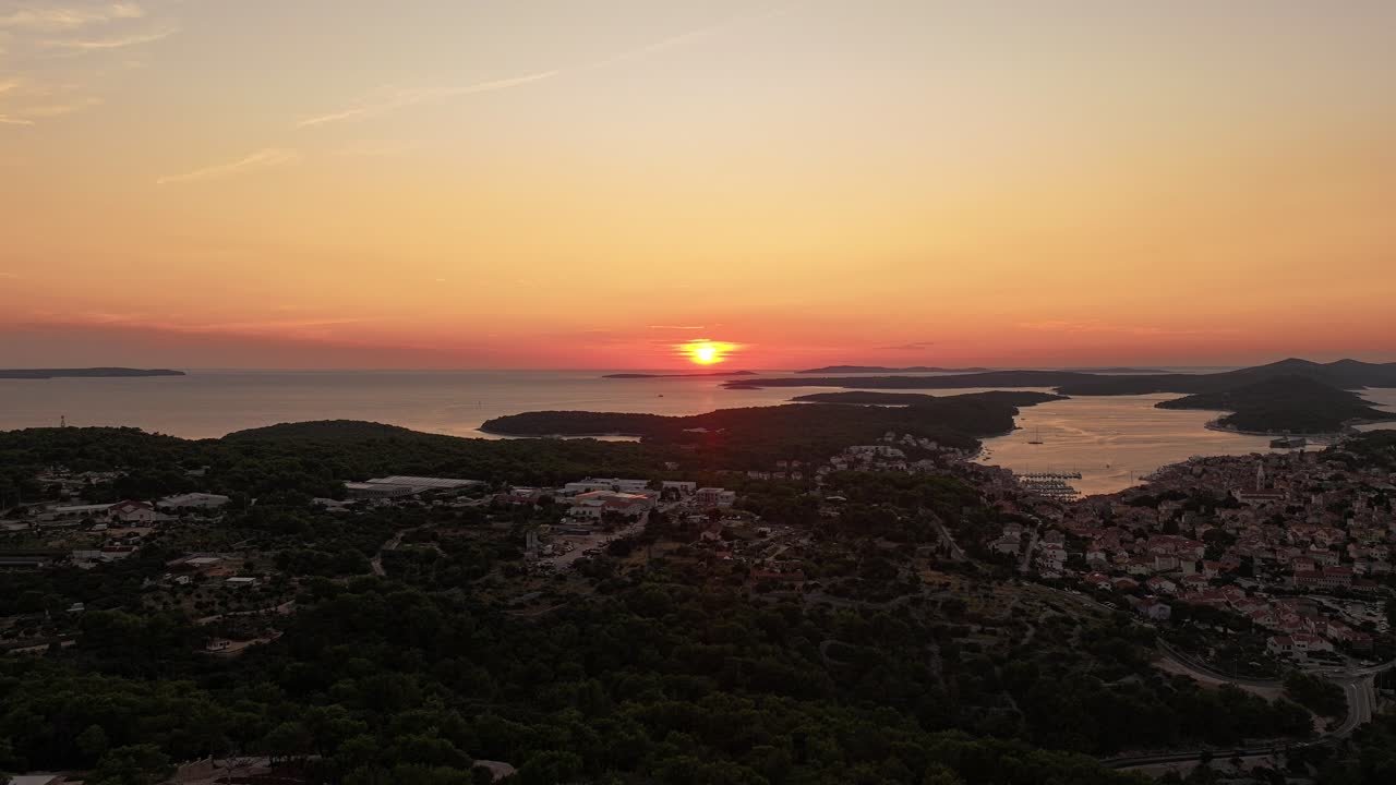 Capture the stunning beauty of Mali Lošinj during golden hour, as the sunset lights up the sky and the coastline. This aerial footage highlights the peaceful charm of the island