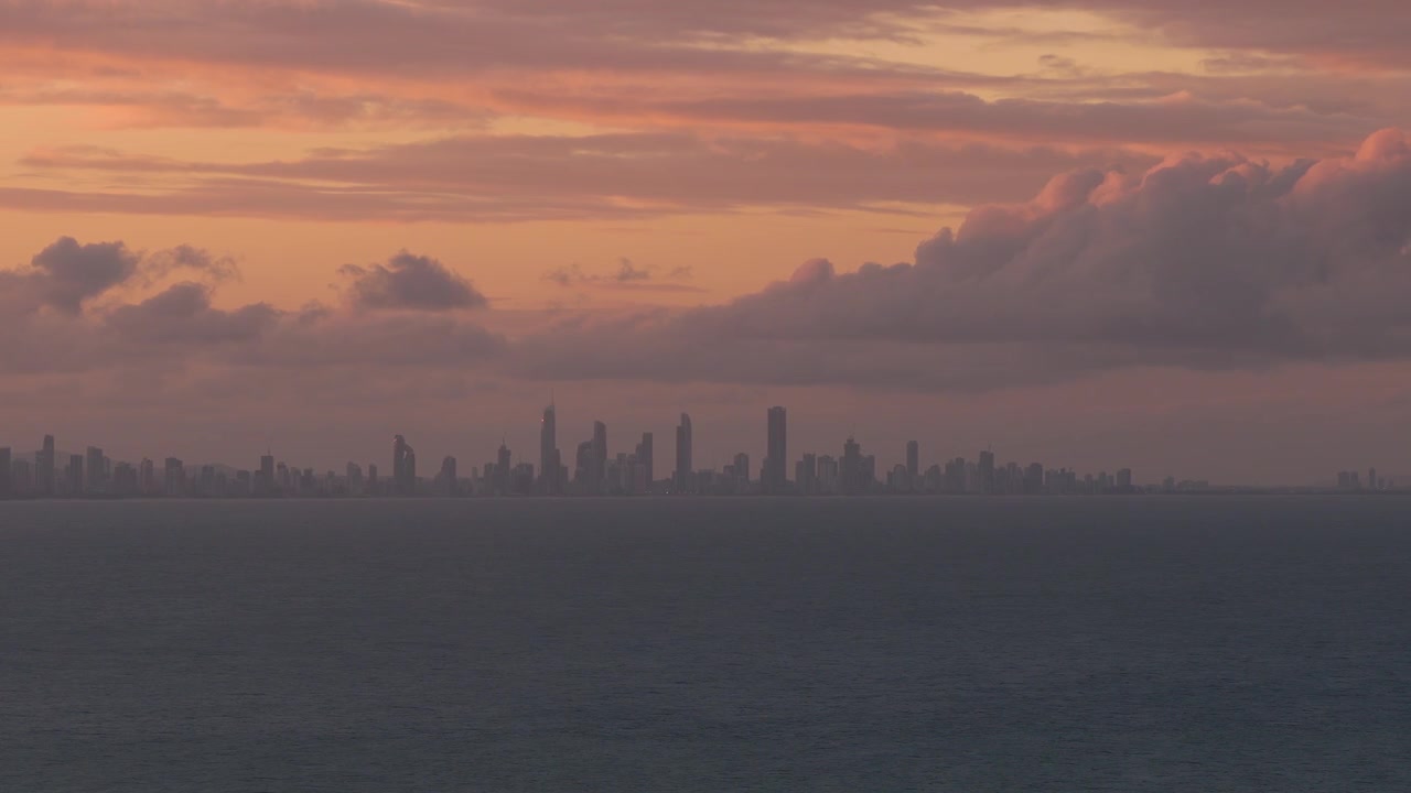 Horizonte de la ciudad de Gold Coast silueteado contra un dramático cielo al atardecer en Queensland, Australia. Toma panorámica