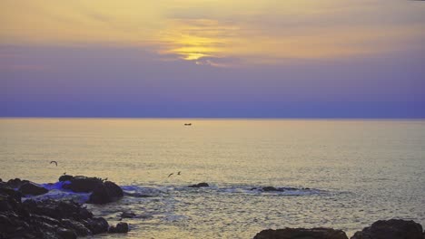 sunset at a rocky coast with overcast sky