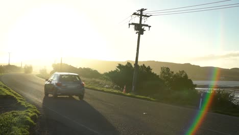 puesta de sol, carretera, autos que pasan y costa del mar oceánico en bluff, nueva zelanda