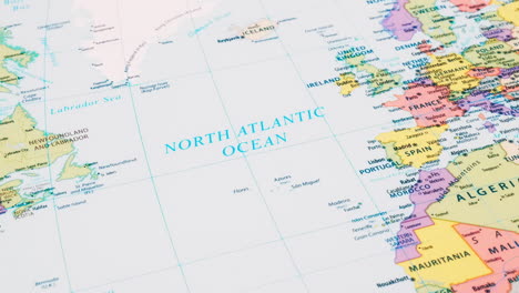 close-up of the word north atlantic ocean on a world map with the detailed name of the capital city