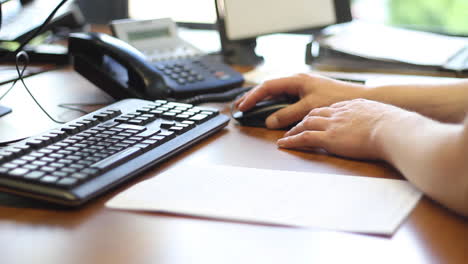 Mano-Femenina-Usando-El-Mouse-De-La-Computadora-Y-Escribiendo-En-El-Teclado-En-La-Oficina-Corporativa