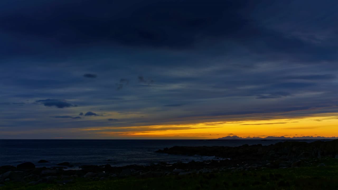 Heavy dark clouds cover midnight sun moving at fast pace over the sea. Overcast and cloudy polar summer night. Time Lapse