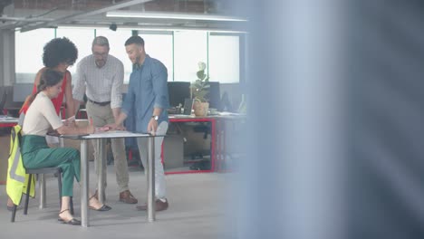 Team-of-diverse-engineers-discussing-over-a-plan-at-office