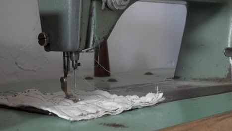 vintage refrey sewing machine in motion stitching cloth indoors
