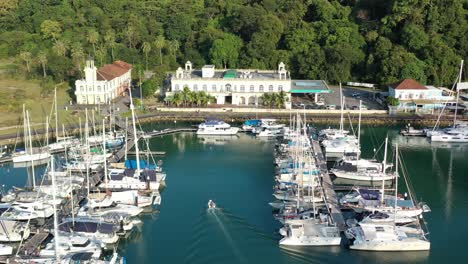 small speedboat sailing back to perdana quay at telaga harbor marina with yachts and sailboats docked in the surroundings at langkawi island, kedah, archipelago of malaysia