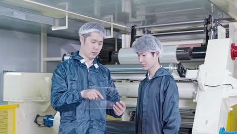 two engineers, male marketing or research workers stand chatting with factory owners discussing product development production lines in the factory, using laptop at industry plant. engineering concept