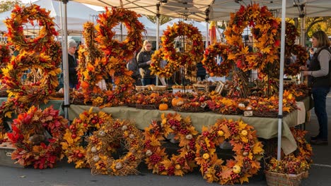 autumn market stall with seasonal wreaths and shoppers