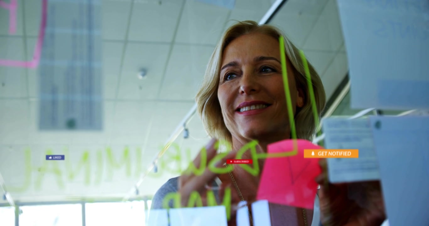 Woman sketching glass in office placing sticky notes organizing ideas as tech alert icons swirling