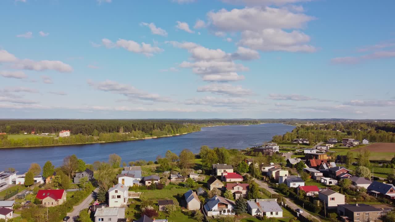 A scenic spring view of Katlakalns residential area along a big river in nature